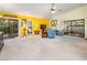 Spacious living room with bright yellow accent wall, ceiling fan, and neutral carpet throughout at 70 Morning Dove Pl, Oldsmar, FL 34677
