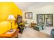 Cozy living room featuring yellow accent wall, seating area with chairs and ottoman, and sliding door at 70 Morning Dove Pl, Oldsmar, FL 34677