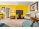 Comfortable living room with television, yellow accent wall, lamps, and upholstered arm chair at 70 Morning Dove Pl, Oldsmar, FL 34677