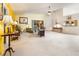 Open living room with bright yellow accent wall, neutral carpet, and view into the kitchen at 70 Morning Dove Pl, Oldsmar, FL 34677