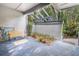 Relaxing patio space with an open-beam ceiling, bench seating, potted plants, and a tranquil view of the surrounding greenery at 70 Morning Dove Pl, Oldsmar, FL 34677