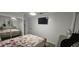 Cozy bedroom with light walls, floral bedding, and a wall-mounted TV for comfortable viewing at 7515 Brookhaven Ct, Tampa, FL 33634