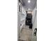 Compact laundry area featuring stacked washer and dryer and shelving for storage at 7515 Brookhaven Ct, Tampa, FL 33634