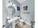 Stylish half-bathroom features a pedestal sink, modern fixtures, and attractive wall decor at 7849 52Nd E Ter, Bradenton, FL 34203