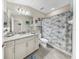 Well-lit bathroom with gray tile flooring, a vanity with granite top, and a shower with a decorative curtain at 7849 52Nd E Ter, Bradenton, FL 34203