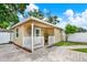 Charming backyard house featuring a covered porch, decorative accents, and lush landscaping at 801 Kirkcaldy Way, Valrico, FL 33594