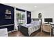 Bedroom with wood floors and furniture and blue accent wall and large window at 801 Kirkcaldy Way, Valrico, FL 33594