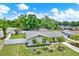 Well-maintained single-story home with a lush green lawn, mature trees, and a white picket fence at 801 Kirkcaldy Way, Valrico, FL 33594