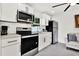 Modern kitchen with stainless steel appliances, white cabinetry, and quartz countertops at 801 Kirkcaldy Way, Valrico, FL 33594