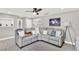 Bright living room featuring a gray sectional sofa, hardwood floors, and artwork at 801 Kirkcaldy Way, Valrico, FL 33594