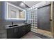 Modern bathroom with a dual sink vanity, illuminated mirror, and glass block shower wall at 805 Paris S Ave, St Petersburg, FL 33701