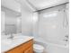 White tiled bathroom with a wooden vanity and shower with bathtub combo at 8806 Bayaud Dr, Tampa, FL 33626