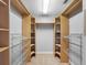 Walk-in closet featuring wood shelving, hanging rods, and carpeted flooring for storage solutions at 8806 Bayaud Dr, Tampa, FL 33626