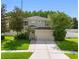 Charming two-story home with landscaped yard, mature trees, and a brick-paved walkway at 8806 Bayaud Dr, Tampa, FL 33626