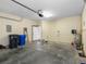 Spacious garage with concrete floor, storage shelves, and an automatic door opener system at 8806 Bayaud Dr, Tampa, FL 33626