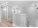 Upstairs hallway with hardwood flooring and access to bathroom and bedrooms at 8806 Bayaud Dr, Tampa, FL 33626