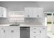 Bright kitchen with stainless steel dishwasher, sink, and white shaker cabinets at 8806 Bayaud Dr, Tampa, FL 33626