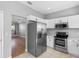 Kitchen with stainless steel appliances and white cabinets, adjacent to the living area at 8806 Bayaud Dr, Tampa, FL 33626
