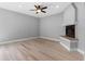 Cozy living room with fireplace, hardwood floors, and ceiling fan at 8806 Bayaud Dr, Tampa, FL 33626