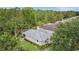Aerial view of a charming single-story home featuring a verdant garden, mature trees, and neutral tones at 9327 Hunters Park Way, Tampa, FL 33647