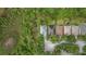 Aerial view of home featuring a well-manicured lawn and garden in a verdant, tree-lined suburban neighborhood on a sunny day at 9327 Hunters Park Way, Tampa, FL 33647