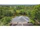 Aerial view of the back side of a beige home with a grey tile roof, screened in porch, and well maintained yard at 9327 Hunters Park Way, Tampa, FL 33647