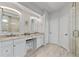 Elegant bathroom featuring double vanity, stylish mirrors, and glass-enclosed shower at 9327 Hunters Park Way, Tampa, FL 33647
