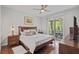 Inviting bedroom with hardwood floors and sliding door to the screened porch at 9327 Hunters Park Way, Tampa, FL 33647