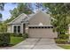Inviting home featuring a neutral color scheme, meticulously landscaped front yard, and convenient two-car garage at 9327 Hunters Park Way, Tampa, FL 33647