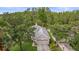 Aerial view of a single-story home with a well-maintained lawn, mature trees, and a neutral-toned exterior on a sunny day at 9327 Hunters Park Way, Tampa, FL 33647