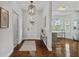 Bright and inviting foyer featuring gleaming wood floors, modern lighting, and an open layout at 9327 Hunters Park Way, Tampa, FL 33647