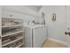 Functional laundry room with a modern washer and dryer, plus storage shelving at 9327 Hunters Park Way, Tampa, FL 33647