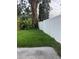 Large green backyard enclosed by a white fence and lush landscaping at 9907 Maggie St, Gibsonton, FL 33534