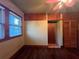 This bedroom features hardwood floors, a window with blinds, wood paneling, and a closet at 9907 Maggie St, Gibsonton, FL 33534