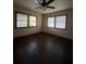 This bedroom features hardwood floors, two large windows with blinds, and a ceiling fan with lights at 9907 Maggie St, Gibsonton, FL 33534