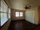 A bedroom showcases hardwood floors, a closet, two large windows, and a ceiling fan with lights at 9907 Maggie St, Gibsonton, FL 33534