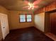 This bedroom features hardwood floors, a window with blinds, a closet, and a ceiling fan with lights at 9907 Maggie St, Gibsonton, FL 33534