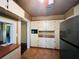 Classic kitchen features ample cabinetry, tile flooring, and stainless steel refrigerator at 9907 Maggie St, Gibsonton, FL 33534
