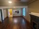 Spacious living room with hardwood floors, view into the kitchen, and a cozy fireplace at 9907 Maggie St, Gibsonton, FL 33534