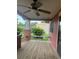 A relaxing porch with wooden floors, brick pillars, and a ceiling fan for comfortable outdoor living at 9907 Maggie St, Gibsonton, FL 33534