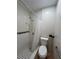 Bathroom view featuring a white tiled shower and toilet with black and white floor tiles at 9907 Maggie St, Gibsonton, FL 33534