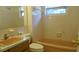 Traditional bathroom featuring a vanity, toilet, and bathtub with tiled walls and window at 10871 86Th Ave, Seminole, FL 33772