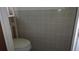 Bathroom with a toilet against tiled walls; simple design with a window providing light at 10871 86Th Ave, Seminole, FL 33772