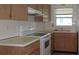 A functional kitchen featuring wood cabinetry, white appliances, and a bright, inviting atmosphere at 10871 86Th Ave, Seminole, FL 33772