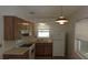 Functional kitchen with wood cabinetry, white appliances, and a window above the sink at 10871 86Th Ave, Seminole, FL 33772