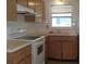 A kitchen with white appliances, wood cabinets, and a window for natural light at 10871 86Th Ave, Seminole, FL 33772