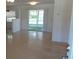 Sunlit living area with terrazzo floors, leading to a screened lanai through sliding glass doors at 10871 86Th Ave, Seminole, FL 33772