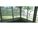Inside the screened porch with a green floor and views of the green lawn and foliage beyond at 10871 86Th Ave, Seminole, FL 33772