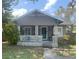 Charming bungalow with a covered front porch and mature landscaping at 1105 E Ellicott St, Tampa, FL 33603