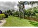 Backyard featuring a serene pond, palm trees and manicured lawn, enhancing the property's appeal and tranquility at 11121 Clayridge Dr, Tampa, FL 33635